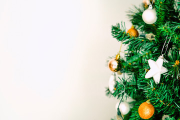 Selective focus view of a Christmas tree decoration, shiny star and colorful balls, with white background. Banner style aesthetics.