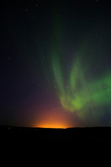 Auroras are the result of disturbances in the magnetosphere caused by solar wind. These disturbances are sometimes strong enough to alter the trajectories of charged particles in both solar wind.