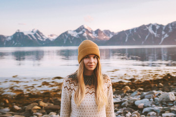 Young woman outdoors travel adventure vacations in Norway sunset mountains and fjord landscape...