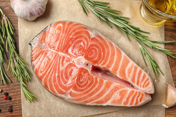 Fresh raw salmon and products on wooden table, flat lay. Fish delicacy