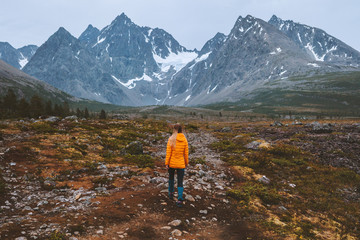 Fototapeta premium Traveler girl hiking in mountains outdoor adventure active vacations alone healthy lifestyle woman exploring Lyngen Alps in Norway