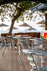 Nook of street cafee with several metal chairs and tables near sea. Turkey.