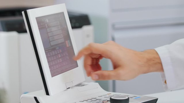 Ophthalmology treatment - a doctor working with a special equipment for checking the visual acuity - tapping on the screen