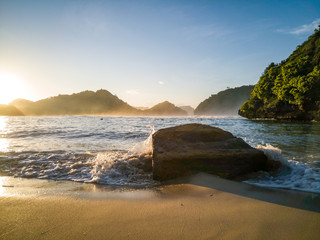 Obraz premium Wonderful view rock hit by weaves on beach in the morning