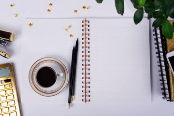Blank page of paper in  open notebook with mock up on the white modern office desk. Black coffee...