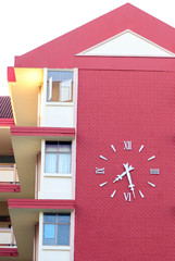 The clock on the red building background