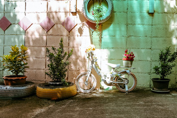 The playground is decorated with wheels. And a child bike decorated with flowers in the background