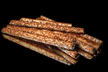 Salted snacks with sesame seeds with reflection on shiny black background