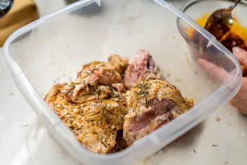 Marinated Raw Chicken Legs with Tomato Sauce, Onions, Rosemary and Potatoes Ready to Bake in Oven.