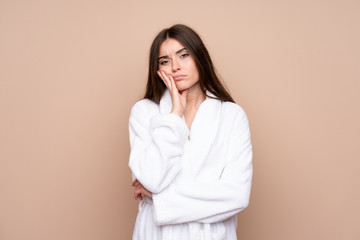 Young girl in a bathrobe over isolated background unhappy and frustrated