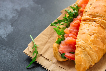 fish sandwich and greens, Smorrebrod (salted salmon, croissant, bread, arugula and other ingredients) menu concept. food background. top view. copy space