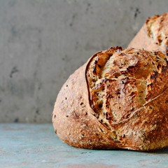 Homemade Freshly Baked Country Bread  made from wheat and whole grain flour on a gray-blue background. French Freshly baked bread.
