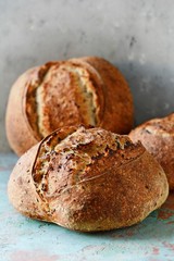 Homemade Freshly Baked Country Bread  made from wheat and whole grain flour on a gray-blue background. French Freshly baked bread.