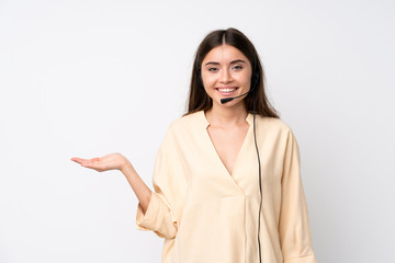 Young telemarketer woman over isolated white background holding copyspace imaginary on the palm