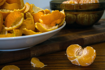 Peeled tangerines and peel on a plate on the table