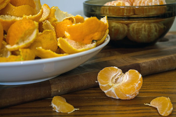 Peeled tangerines and peel on a plate on the table