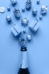 Champagne bottle with different christmas decoration on blue background. New year concept.