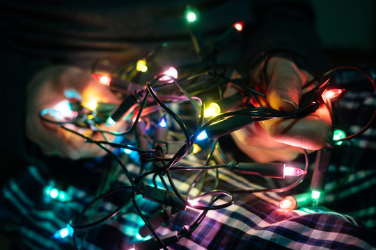 Man trying to untangle Christmas lights