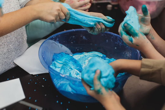 a-little-girl-hands-making-slime-herself-on-blue-wooden-background-slime- making-hand-children-toy_t20_rRaG0g - The Breakie Bunch Learning Center