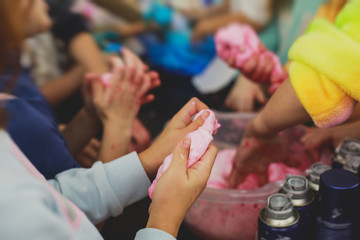Group of kids making a multicoloured slime, pink, blue and white slime toy on kids birthday party, kid playing with slime, homemade slime