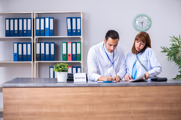 Two doctors working at the reception in the hospital