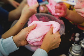 Group of kids making a multicoloured slime, pink, blue and white slime toy on kids birthday party,...