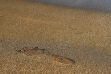 Beach, sand, barefoot footprint, water washes away trace