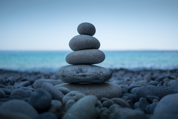 Fototapeta na wymiar Pyramid of stones for meditation lying on the sea coast at Crete island