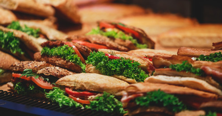 Beautifully decorated catering banquet table with different food snacks and appetizers with sandwich, on corporate christmas birthday kids party event or wedding celebration