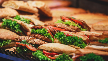 Beautifully decorated catering banquet table with different food snacks and appetizers with sandwich, on corporate christmas birthday kids party event or wedding celebration