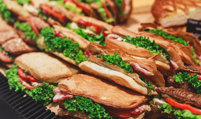 Beautifully decorated catering banquet table with different food snacks and appetizers with sandwich, on corporate christmas birthday kids party event or wedding celebration