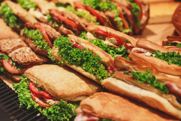 Beautifully decorated catering banquet table with different food snacks and appetizers with sandwich, on corporate christmas birthday kids party event or wedding celebration