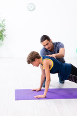 Young father and his son doing exercises