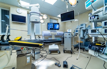 establishing shot of technologically advanced operating room ready for surgery. real modern operating theater with working equipment, lights and computers.