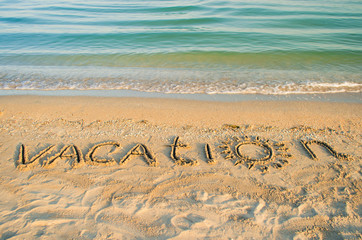 The inscription vacation on sand. Shooting on the beach. 