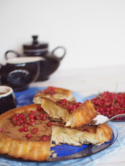 pie or muffin with apples on a plate in blue classic color with tea in the kitchen