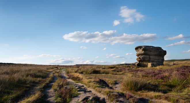 Eagle Stone on Froggatt Edge in the Derbyshire Peak district, UK. Summer moorland with heather