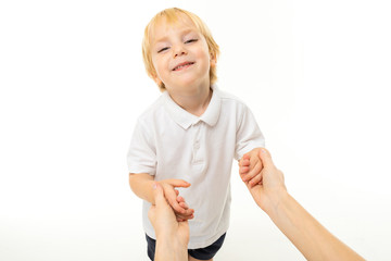 little caucasian boy with fair red hair smiles and holds his dads hands , portrait isolated on white background