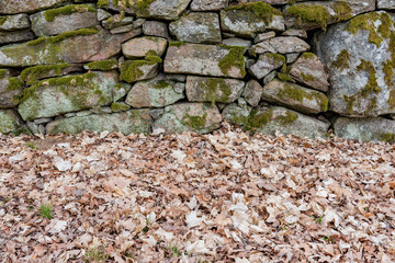 an old manmade stone wall with moss on it