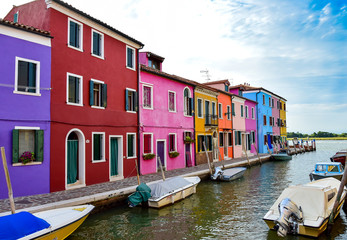 Fototapeta na wymiar Street with colorful houses, red, yellow, green, blue, canal river with boats, summer, afternoon. Burano, Venice / Italy.