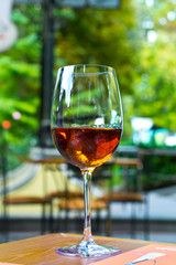 glass of wine on wooden table in garden
