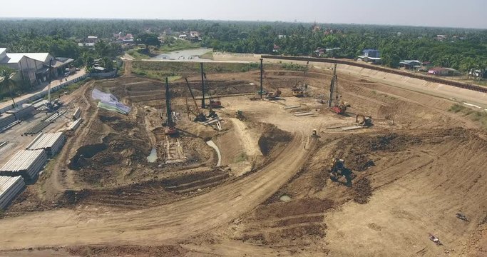  drone shot : fly over the construction site. Heavy machinery, such as drills, excavators, trucks, cranes, and other equipment is used to construct new buildings