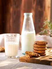Oatmeal Cookies On A Wooden Board On A Sunny Day With A Glass And A Bottle Of Milk.