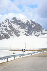 View of asphalt road and mountain peaks in Dolomites