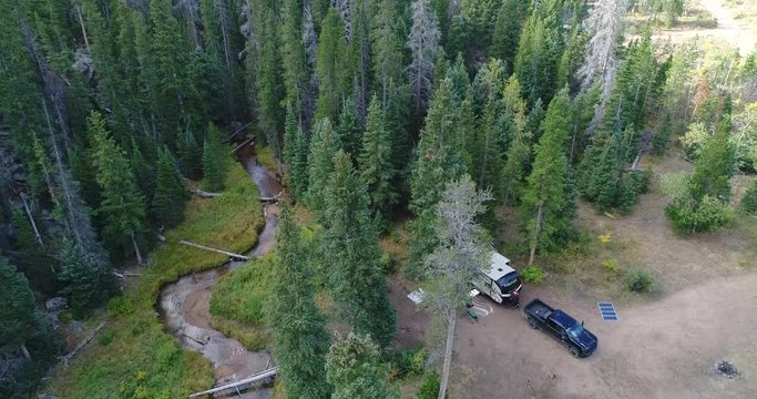 Drone flight over an RV using solar panels for power in forest