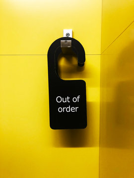 out of order sign on a yellow wall 