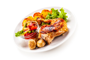 Barbecued chicken leg with chips and vegetables on white background