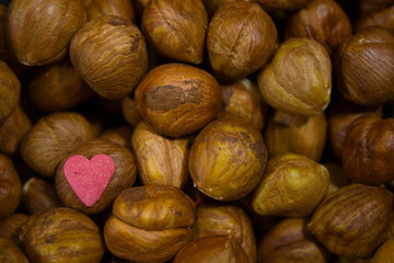 plate with nuts on a gray background with scattered hearts