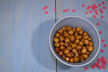 plate with nuts on a gray background with scattered hearts