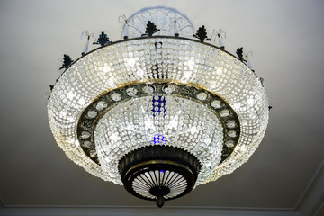 Naklejka premium Luxurious Palace large chandelier. Light In the interior of a Grand room.